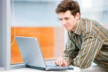 Man researching roofing industry on a lap top computer